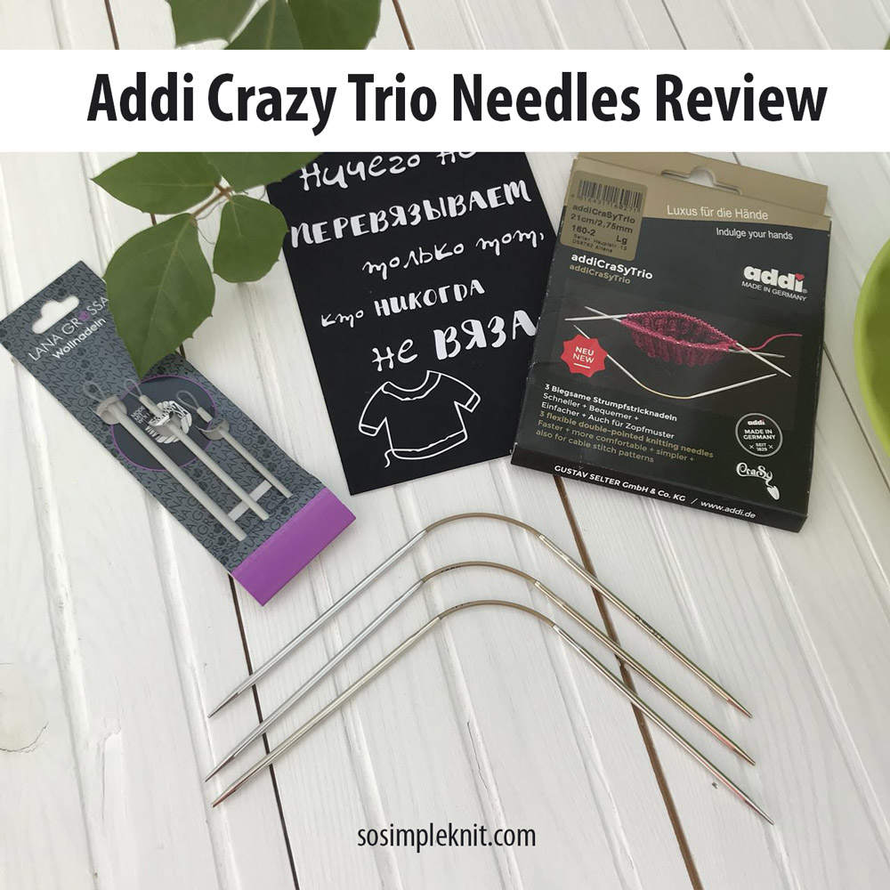 Addi Crasy Trio flexible sock needles review. The image shows a top-down composition featuring a set of three Addi Crazy Trio needles in their original black and gold packaging, alongside Lana Grossa Wollnadeln. Next to them lies a black card with Russian text that reads: 'Only those who never knit don't have to re-knit anything.' Green leaves are scattered on a light wooden table. The image includes the header 'Addi Crazy Trio Needles Review' at the top and the website logo 'sosimpleknit.com'