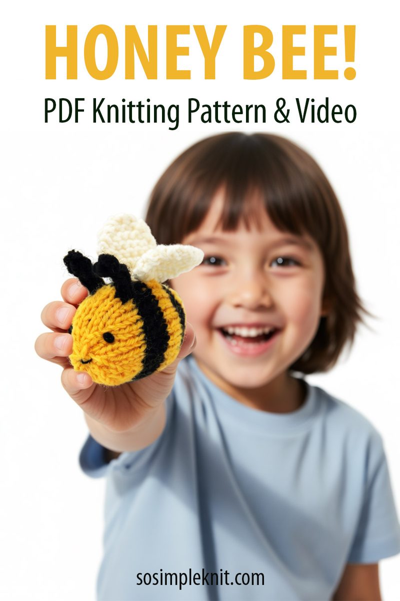A young child with a joyful expression holds up a knitted honey bee toy. The bee is black and yellow with white wings. The child is wearing a light blue shirt and has dark hair. The background is plain and light-colored to emphasize the child and the toy. The words "HONEY BEE!" are displayed prominently above, along with the text "PDF Knitting Pattern & Video" below.