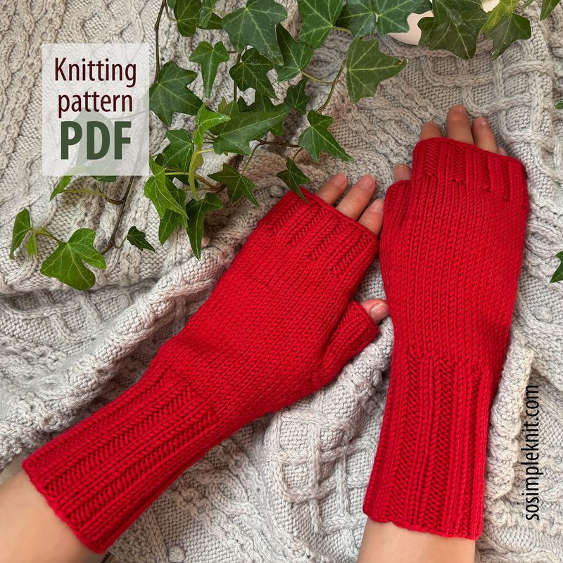 A pair of bright red fingerless gloves made from a textured yarn pattern is displayed on a soft, knitted ivory background. The gloves feature ribbed edges and openings for the fingers, showcasing a close-up view of the knit details. To the left, there is a graphic text overlay that reads "Knitting pattern PDF." In the background, green ivy leaves add a touch of nature to the scene. The overall composition emphasizes the gloves while highlighting the intricate knit design.