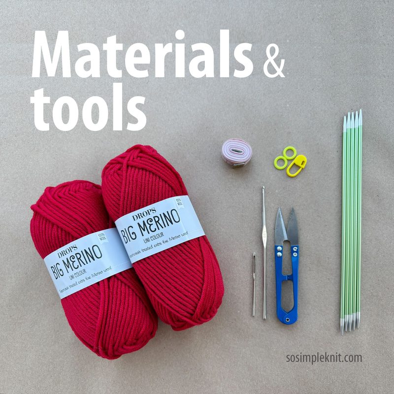 The image features two skeins of bright red yarn labeled "DROPS BIG MERINO," lying next to a roll of pink tape measure, a pair of small silver scissors, a blue crochet hook, two stitch markers, and three green double-pointed knitting needles. The items are arranged on a light beige background, with "Materials & tools" displayed in bold white text above.