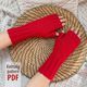 Detailed image of two hands in bright red knitted fingerless gloves. The hands rest on a textured woven tray on top of a knitted blanket. A text overlay is visible: "Knitting pattern PDF"