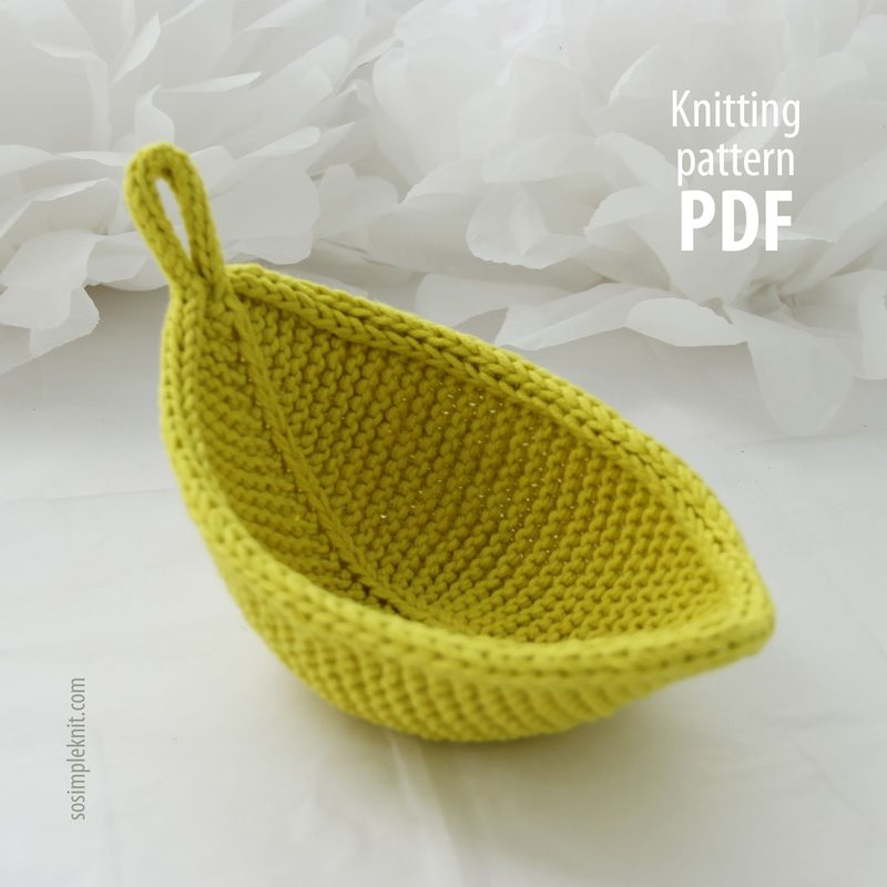 Light green leaf-shaped knitted coaster on an elegantly set table, cozy and stylish kitchen accessory, Leaf Coaster knitting pattern.