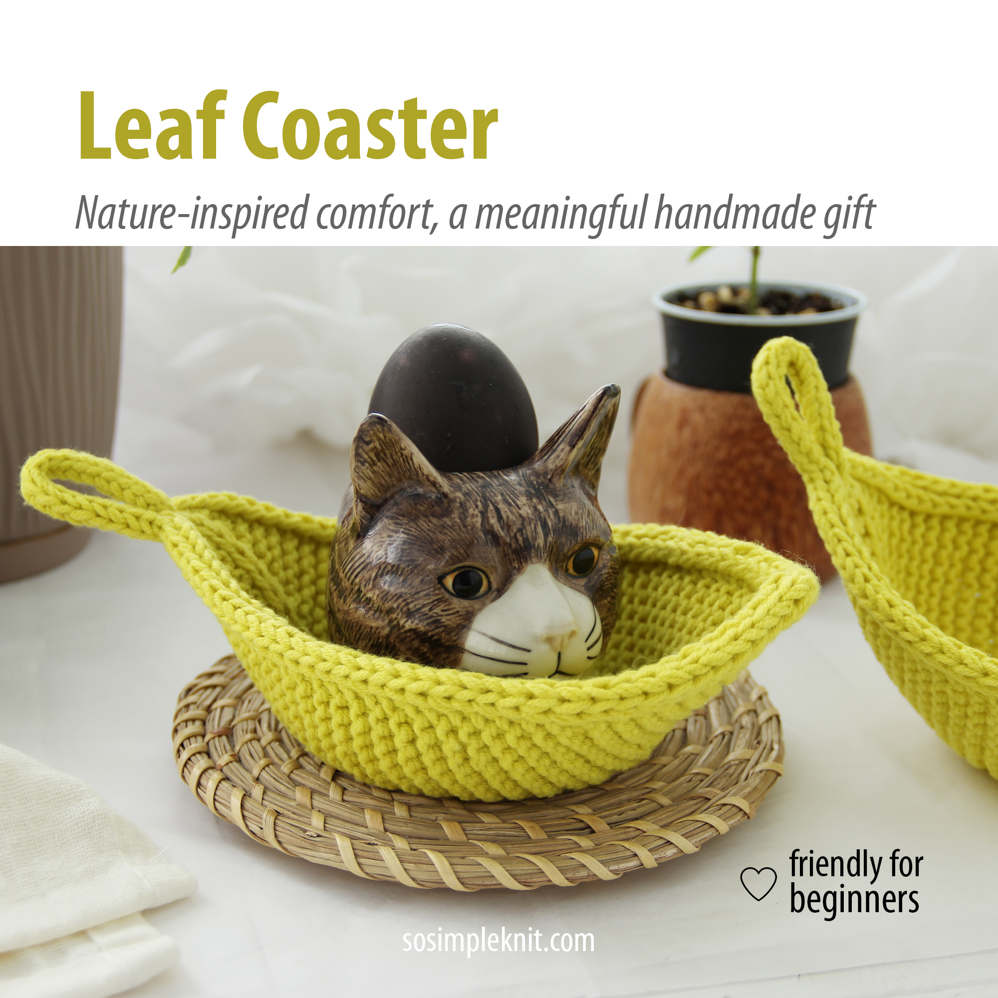 Styled table setting with a knitted leaf-shaped coaster (Leaf Coaster), holding a small cat-head-shaped stand with a dark grey dyed egg, creative decorative arrangement.