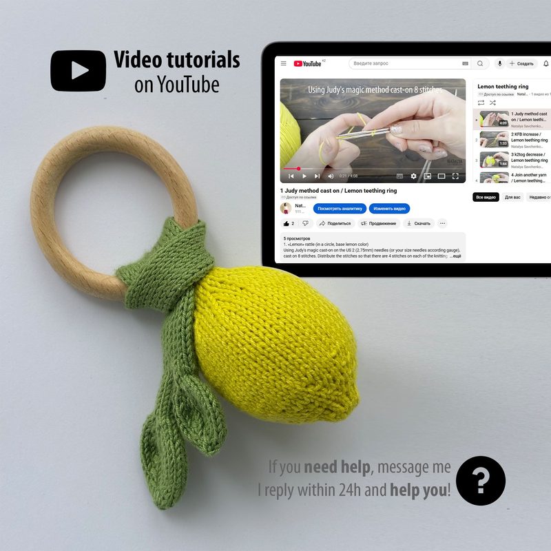 The image features a knitted lemon rattle in vibrant yellow, with green knitted leaves attached, resting on a light gray surface. In the background is a computer screen displaying a YouTube video tutorial with text that reads "Using Judy's magic method cast on a stitch," along with other video options visible. The overall composition highlights the knitted item in the foreground, while the screen provides context for learning how to create the pattern.