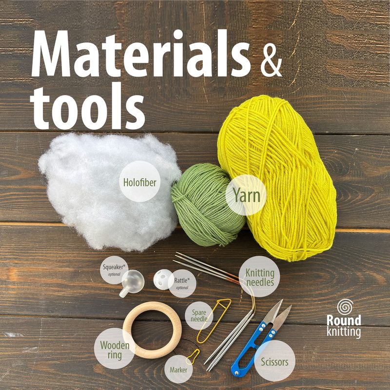 The image displays a flat lay of materials for the "Lemon Rattle Knitting Pattern" on a wooden background. It includes a bright yellow ball of yarn, a green ball of yarn, white holofiber stuffing, a wooden ring, and various knitting tools such as knitting needles, a spare needle, scissors, a marker, and small accessories like a squeaker and a rattle. The items are arranged neatly with labels indicating their names. The color palette features vibrant yellows and greens against the warm brown of t