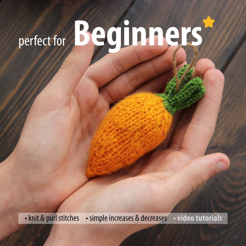 A person's hands hold a small, knitted mini carrot, showcasing vibrant orange for the body and green for the leafy top. The carrot is textured, highlighting knitting stitches, and is neatly presented against a dark wooden background. Above the hands, the word "Beginners" is prominently displayed in a bold font, accompanied by descriptive text below that mentions knitting techniques and video tutorials. The overall composition emphasizes the carrot while offering context for a knitting pattern.
