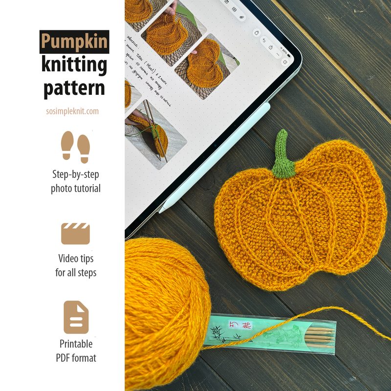 An overhead view of a knitted pumpkin made with a bright orange yarn, featuring a green knitted stem. The pumpkin is placed beside a tablet displaying step-by-step photo tutorials for knitting patterns. A ball of matching orange yarn and a wooden knitting needle are visible. The background is a textured wooden surface, enhancing the cozy crafting atmosphere. The tablet frame includes graphics indicating video tips and printable PDF format for the pattern.
