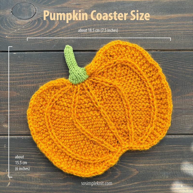 The image features a knitted pumpkin coaster, showcasing a vibrant orange color with textured ridges resembling pumpkin lines. The coaster has a small green knitted stem at the top, and it is laid flat against a dark wooden surface. Measurements are indicated next to the coaster in white text, displaying approximate sizes of 18.5 cm (7.5 inches) and 15.5 cm (6 inches). The overall composition is centered with the pumpkin coaster prominently featured in the foreground.