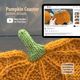 The image features a close-up of a pumpkin-shaped knitted coaster in vibrant orange yarn, with a textured green stem at the top. In the background, there is a tablet displaying a video tutorial related to the pumpkin coaster knitting pattern. The overall color scheme is warm, with the orange and green being prominent. The composition is balanced, focusing on the coaster in the foreground and the tablet providing instructional context.