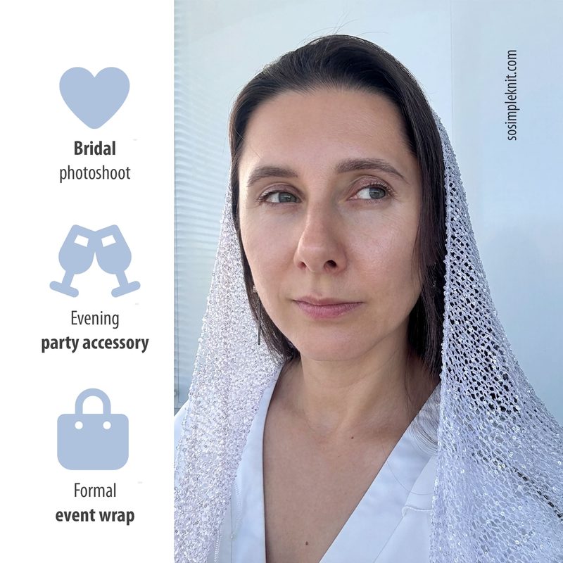 A woman with long brown hair is wearing a shimmering silver sequin shawl draped over her head and shoulders, styled in a simple and elegant manner. The background features a light color and appears bright and airy, suggesting an outdoor setting. The shawl’s texture is reflective, catching the light beautifully. The woman has a neutral expression and wears a white top, contributing to the overall sophisticated look of the image. The framing is centered on the woman, highlighting her face and the