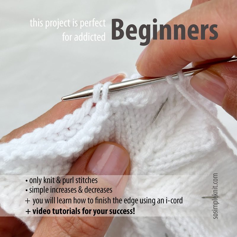 A close-up of a partially knitted white security blanket with a person's hand holding a knitting needle. The hand is positioned near the edge of the blanket, showcasing a few knitted stitches. The background is softly blurred, drawing focus to the knitting process. Additionally, there is text overlaid on the image, indicating that the project is suitable for beginners and highlighting features of the pattern. The overall color scheme is light and soft, emphasizing a cozy, inviting atmosphere.