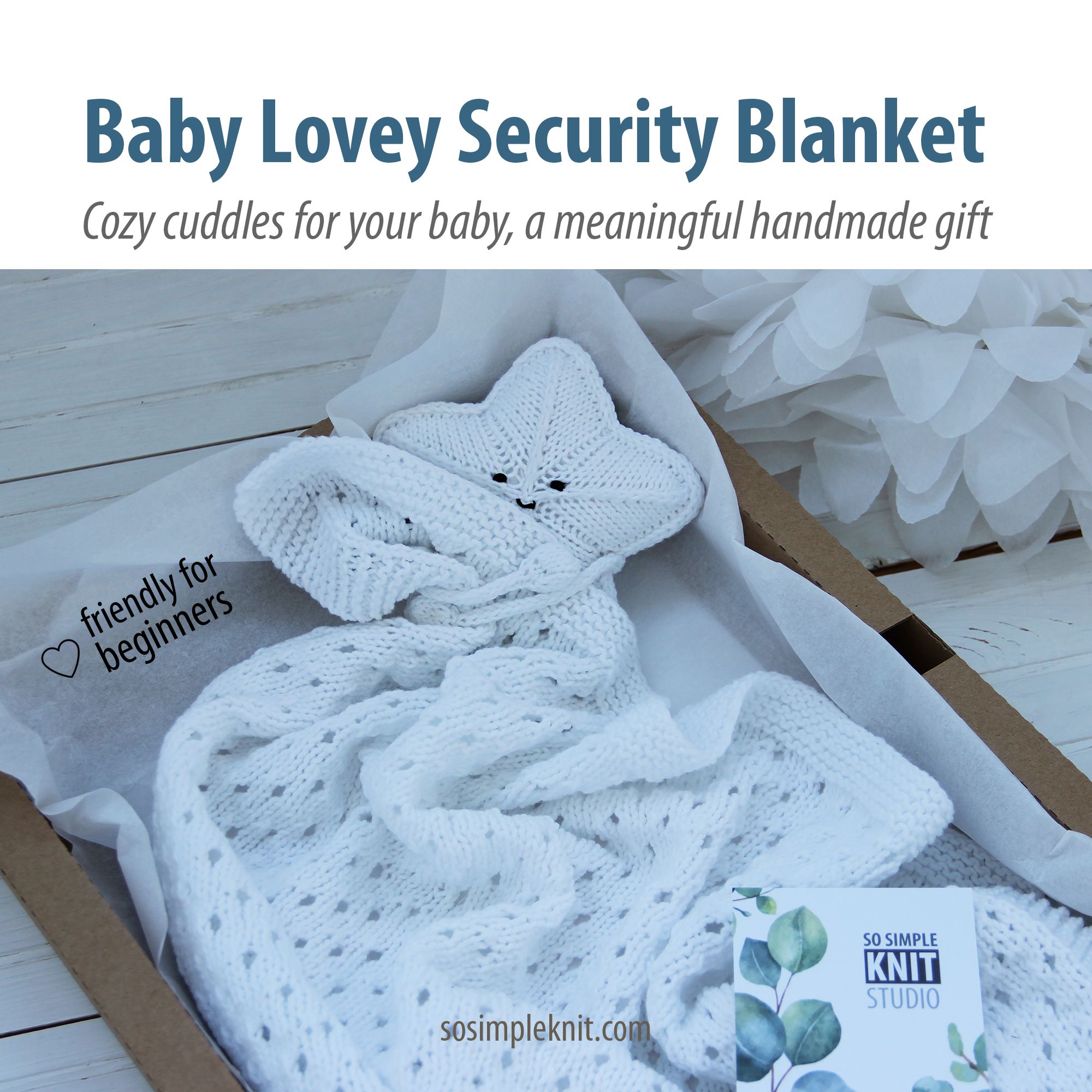 The image shows a soft, knitted baby lovey security blanket with a star-shaped head and arms made of white yarn. The blanket features textured patterns and a gentle drape, with the head appearing at the center. It is arranged in a light-colored box lined with a soft, neutral fabric. In the foreground, a small card displays the brand name "SO SIMPLE KNIT STUDIO." The overall color scheme is soft and calming, with pastel tones. The framing emphasizes the blanket as the central focus against a ligh