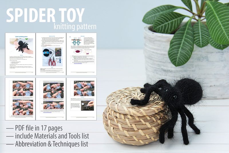 The image features a black knitted toy spider sitting on a woven basket. The spider has eight legs and a textured body, positioned prominently in the foreground. In the background, partial pages of a PDF pattern are visible, displaying instructional text and images related to knitting. A green leafy plant is located to the right, contrasting with the dark color of the spider. The overall composition has a clean, minimalistic aesthetic.